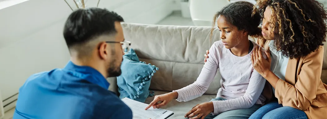Mother and young doctor talking to a community health workers their home