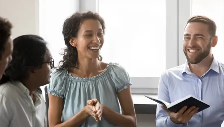 Woman smiling while talking to a group of diverse people