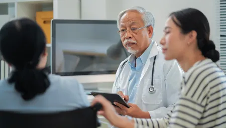 Caregiver accompanies senior woman for medical consultation with doctor