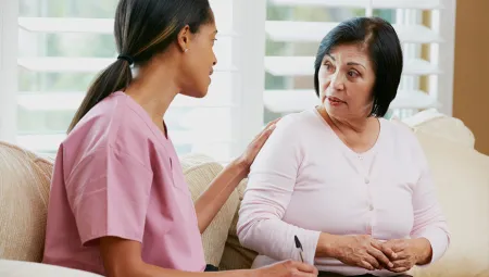 Community Health Worker talking to a middle aged woman with her hand on her shoulder