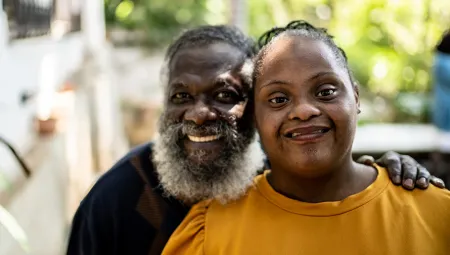 Father smiling next to his daughter with autism
