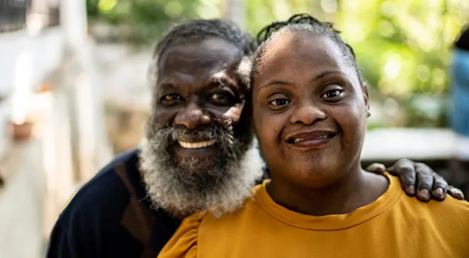 Father smiling next to his daughter with autism