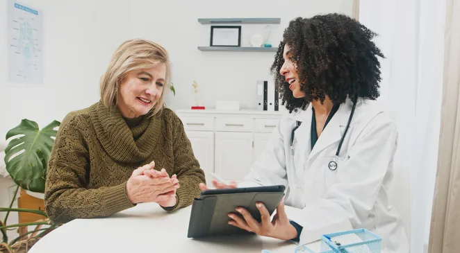 Consultation With a doctor and an elderly woman looking at a tablet