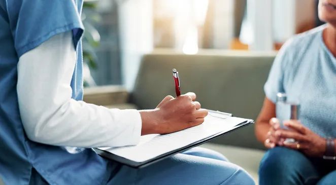 Nurse with a clipboard writing things on a piece of paper