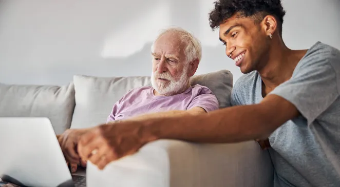 Older man and his caregiver surfing the Internet