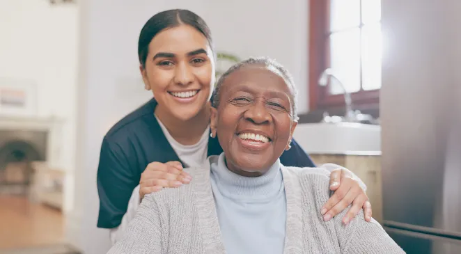 Portrait of caregiver with elderly woman in a wheelchair smiling