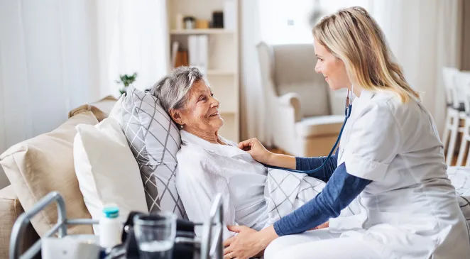Caregiver checking the vitals of an elderly woman at home